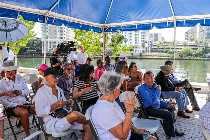 Commissioner Manolo Reyes and CResidents sitting under a tent at the New Baywalk Ribbon Cutting Ceremony Behind First Presbyterian Church on Brickell