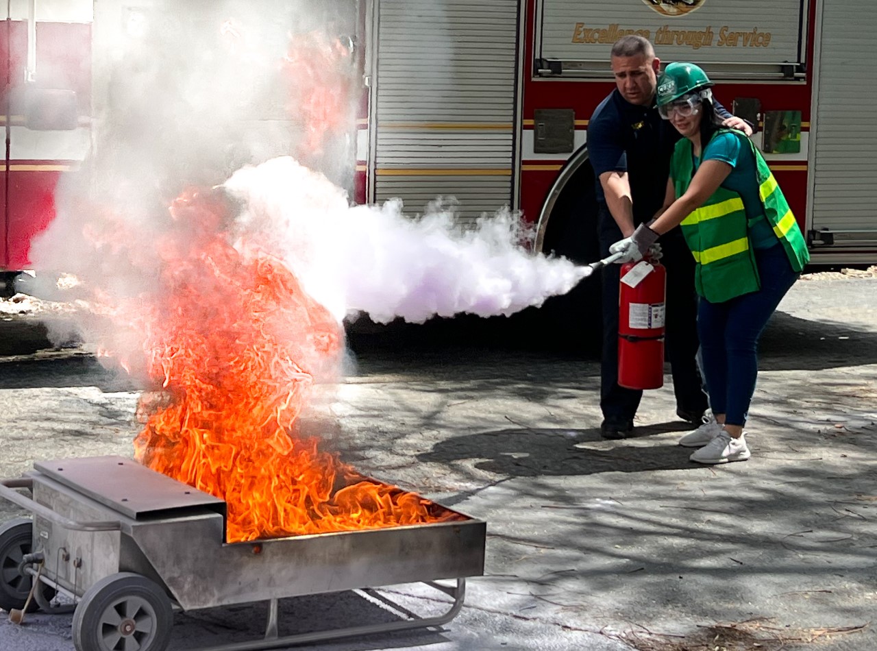 Woman putting out a fire with extinguisher
